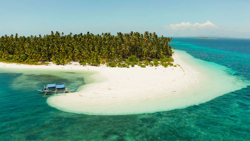 Tropical island with sandy beach by atoll with coral reef and blue sea. patongong island