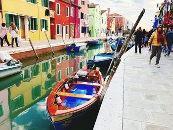 People on boats moored in water