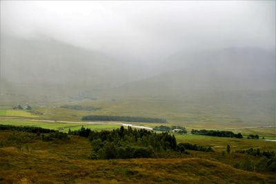 Scenic view of landscape against sky during foggy weather