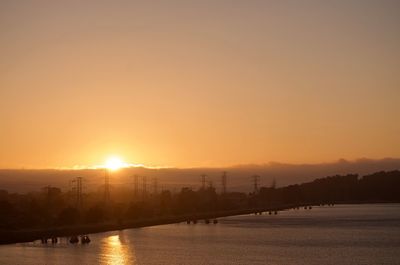 Scenic view of river against orange sky