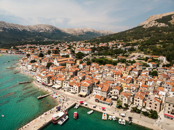High angle view of townscape by sea against sky