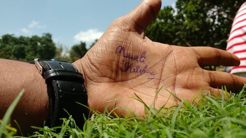 Close-up of hand against sky