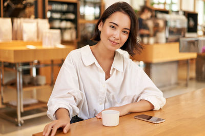 Portrait of young woman working at table