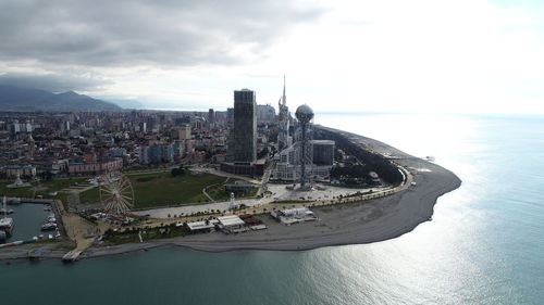 Aerial view of cityscape by sea against sky