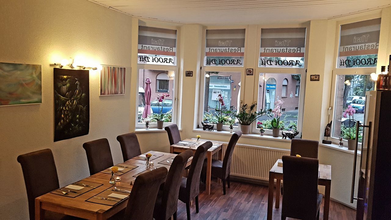 EMPTY CHAIRS AND TABLES IN ILLUMINATED BUILDING AT CAFE