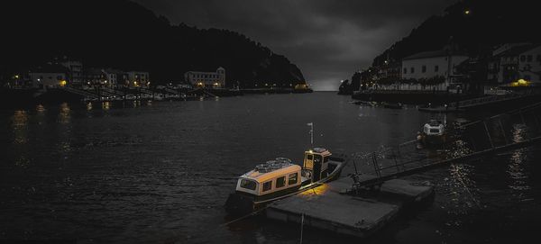 River by illuminated city against sky at night