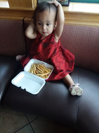 High angle view of cute girl sitting at home