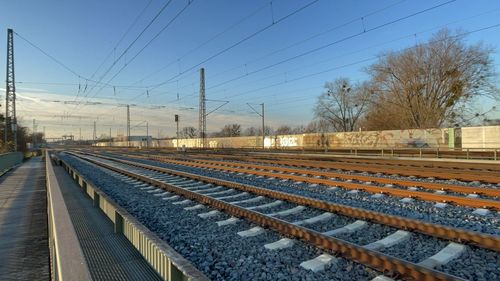 Railroad tracks on field against sky