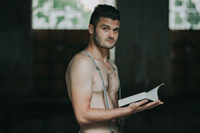 Portrait of young man standing against wall