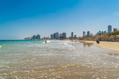 Sea and buildings against clear sky