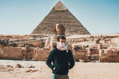 Portrait of man standing against historic building