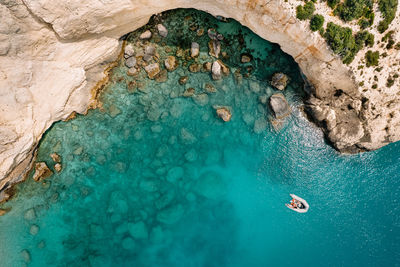 Aerial view of person in boat by cliff