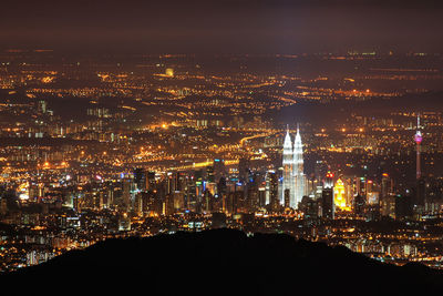 Mid distance view of illuminated petronas tower and kuala lumpur tower at night