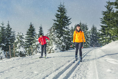 Rear view of people walking on snow covered mountain