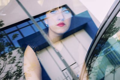 Portrait of young woman sitting in car