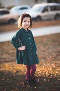 Cute girl with hand on hip standing at park