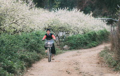 Boy riding bicycle on footpath