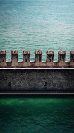 Built structure by sea against blue wall