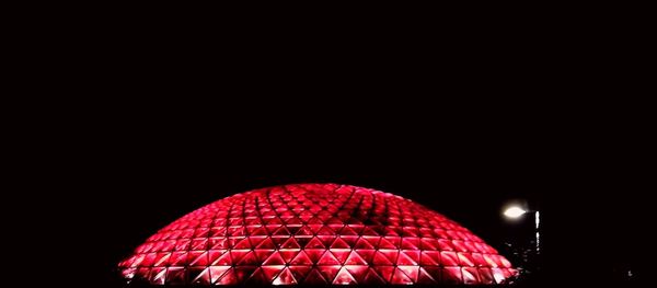 Low angle view of illuminated building against sky at night