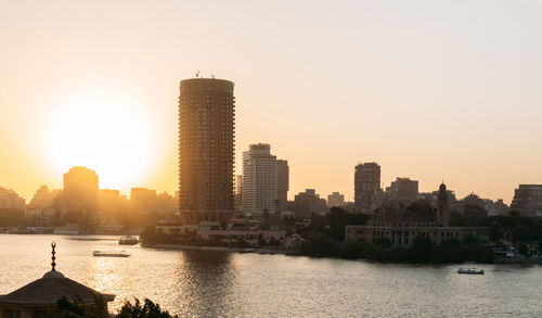 City at waterfront during sunset