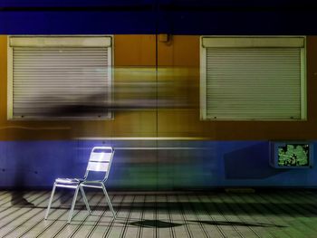 Blur image of person walking next to chair on footpath