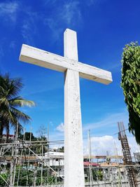 Low angle view of cross against blue sky