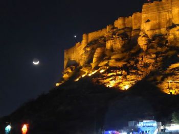 Low angle view of illuminated buildings against sky at night