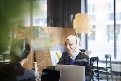 Woman in headscarf sitting in cafe