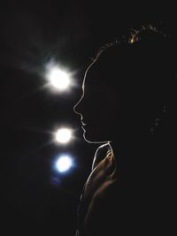 Portrait of woman with illuminated lights at night