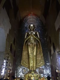 Low angle view of statue against illuminated building