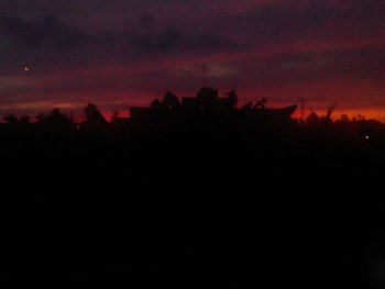 Silhouette trees against sky at night