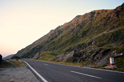 Road by mountain against sky