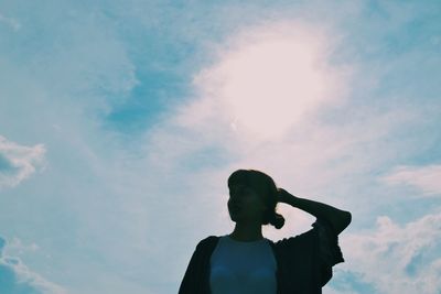 Low angle view of silhouette woman standing against sky