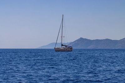 Sailboat sailing on sea against clear sky