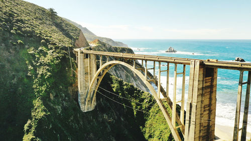 Arch bridge over sea against sky