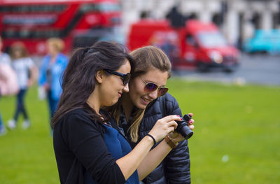 Woman showing camera to friend