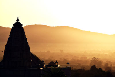 Silhouette nareli jain temple against sky at sunrise