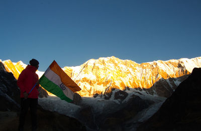 People on rock against sky during winter