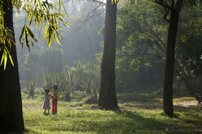 Man standing on field in forest