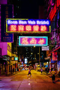 People walking on illuminated street at night