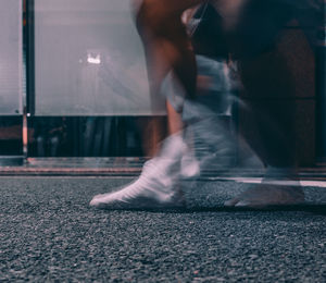 Low section of person running on road in city