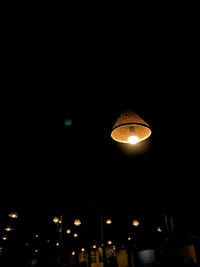 Low angle view of illuminated pendant lights hanging from ceiling