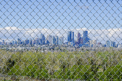 Panoramic view of field seen through chainlink fence