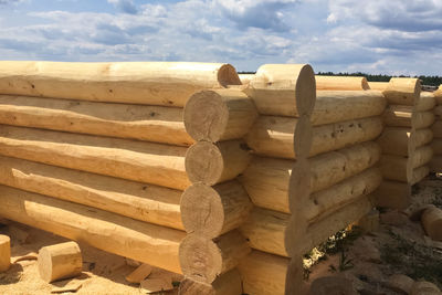 Stack of logs against sky