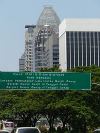 Road sign against sky in city