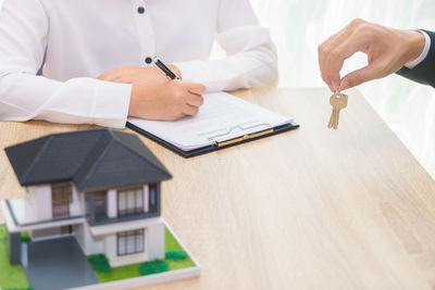 Midsection of man with umbrella on table