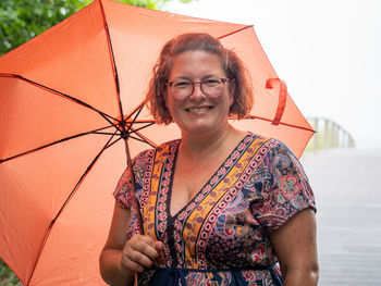 Portrait of young woman with umbrella on beach