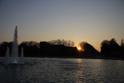 Scenic view of lake against clear sky during sunset