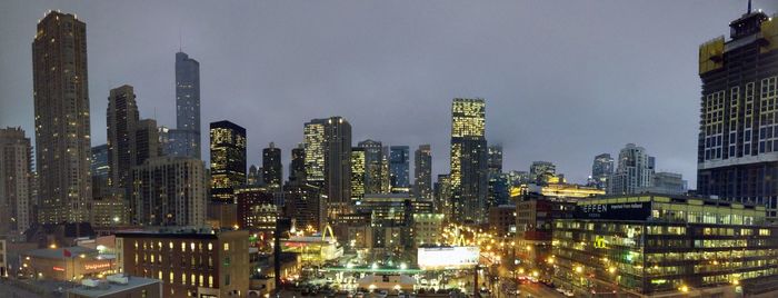 Illuminated cityscape against sky at night