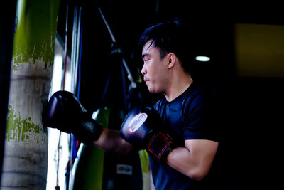 Side view of young man looking at camera